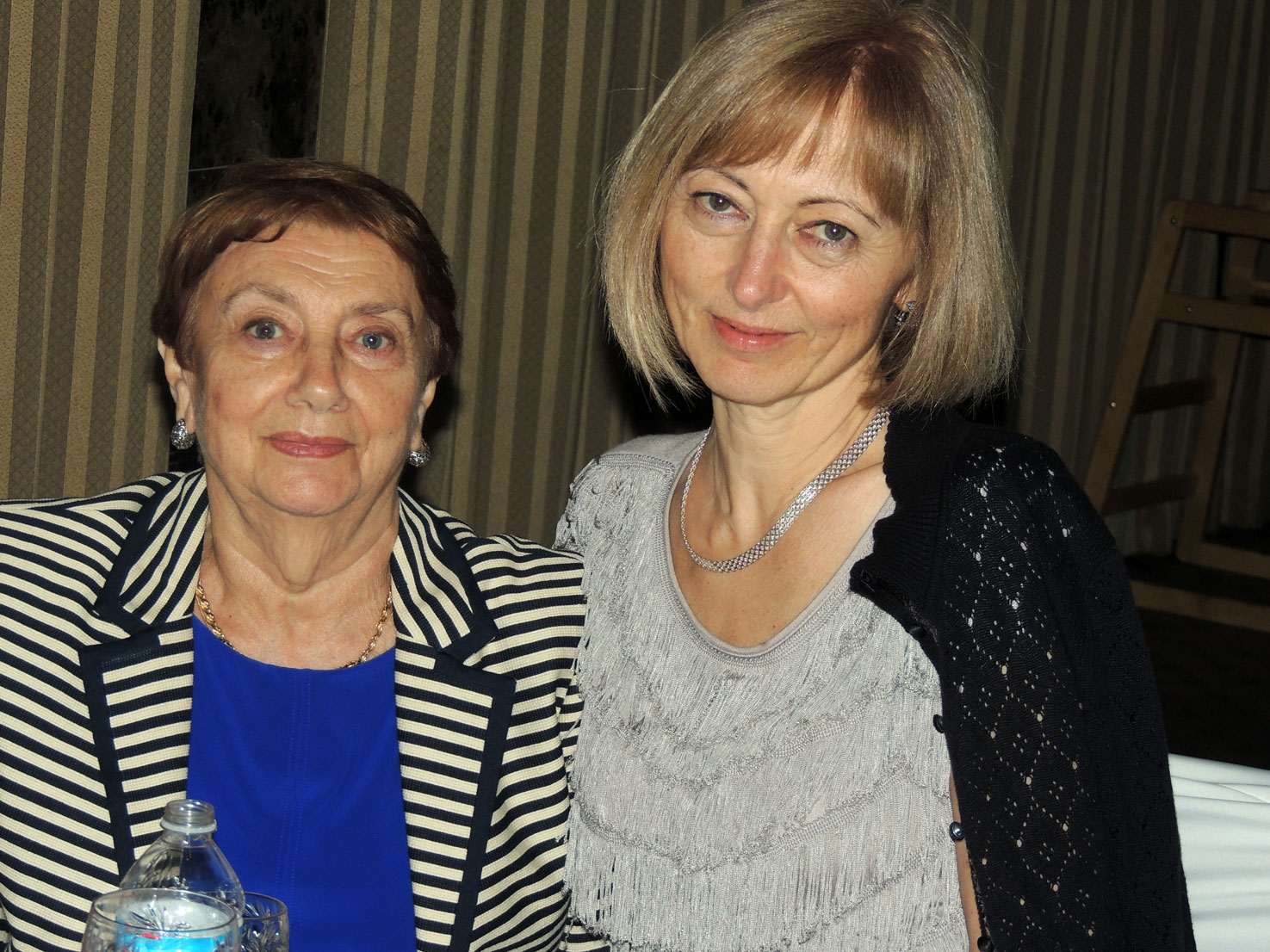 A couple of women posing for a pictureAI-generated content may be incorrect.