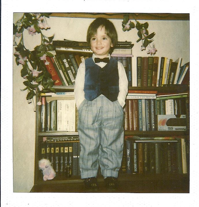A child standing in front of a bookcaseAI-generated content may be incorrect.