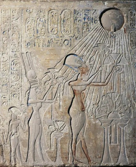 A detail of a painted low relief depicts king Akhenaten and his family adoring the sun god Aten